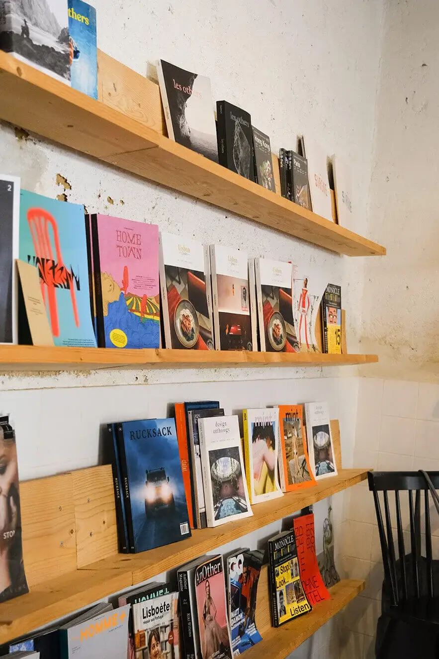 Magazines neatly arranged on wooden shelves at Hello, Kristof specialty coffee shop