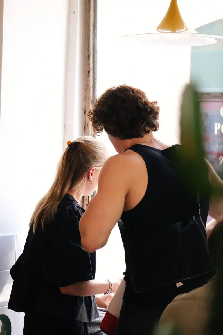 Customers standing near a window, engaging in conversation at Hello, Kristof